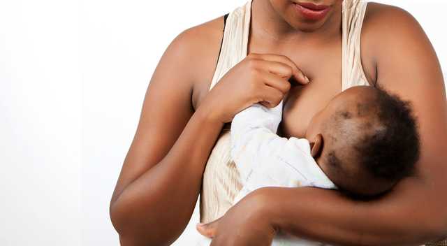 Woman breastfeeding baby postpartum