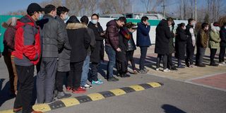 People wait to board shuttle buses to a Covid-19 vaccine center in Beijing on January 5, 2021.