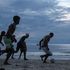 People play football at the Beau Fallon beach in Mahe island in Seychelles.