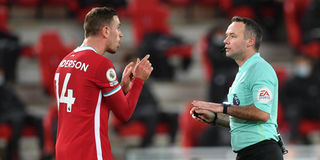 Liverpool captain Jordan Henderson speaks to referee