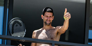 Men's world number one tennis player Novak Djokovic of Serbia gestures to fans from a hotel balcony in Adelaide, South Australia