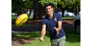 Novak Djokovic plays with a rugby ball