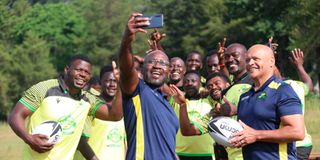 Kabras Sugar head coach Mzingaye Nyathi (left) and assistant coach Jerome Muller take a selfie with players