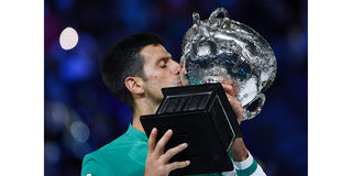 Serbia's Novak Djokovic kisses the Norman Brookes Challenge Cup trophy following his victory