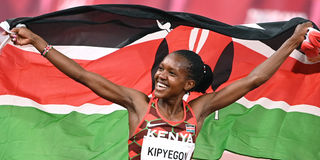 Kenya's Faith Kipyegon celebrates with her flag 