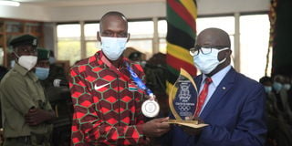 Timothy Cheruiyot receives plaque from Wycliffe Ogallo