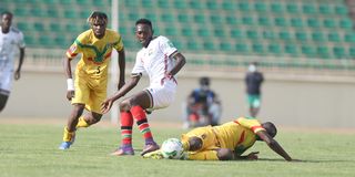 Kenya's midfielder Duke Abuya vies for the ball with Kouame Rominigue and Diadie Samassekou