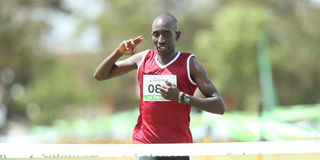 Charles Mneria crosses the finish line to win the men's 10km race during Kenya Prisons Cross Country