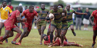 KCB's Andrew Amonde (centre) charges past Nondescript defence 