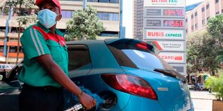 An attendant fuels a car at a filling station.