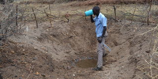 Mwangi Mutegi drinks water from a well 