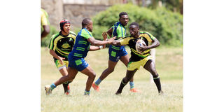 Kabras Sugar scrum half Barry Robinson (right) charges past Ahmed Shaban of KCB 