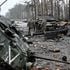Ukrainian servicemen walk next to destroyed Russian tanks 