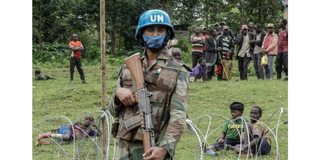 A peacekeeper protects civilians who fled violent clashes