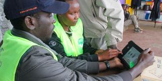 IEBC clerks verifying a voter’s details in Nakuru. 
