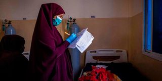 A nurse makes notes in a ward for severely malnourished babies.