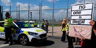 London protester holds up sign in front of police officers