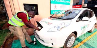 A man plugs in an electric car for charging