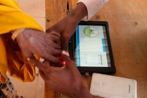 A polling clerk uses a Kiems kit to identify a voter at Wajir Girls High School.