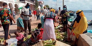 Women scrambling for green maize at the seafront depot near Sunsail hotel in Lamu Town.