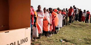 People queue to vote for Kenya's general election at the Masurura primary school polling station.