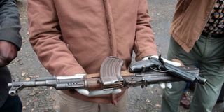 Police at Karatina police station in Nyeri county display an AK47 rifle and a homemade pistol.