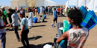 Ethiopian refugees who fled the Tigray conflict gather to receive aid.