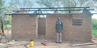 Mr John Achuman in front of his house destroyed by suspected bandits from neighboring West Pokot County