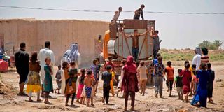 People collect water from a cistern in al-Aghawat, Iraq