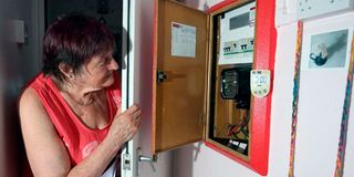 Pensioner Diane Skidmore examines her smart meter in London.