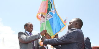 Former Laikipia Governor Ndiritu Muriithi hands a flag to his successor Joshua Irungu.