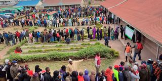 Kenyan voters wait in line to cast their ballots on August 9, 2022.