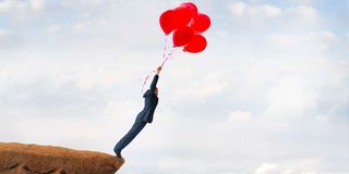 man falling off cliff red balloons 