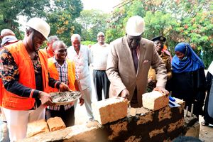 Education Cabinet Secretary Prof. George Magoha puts a Construction Block at Bomu Secondary School.