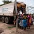 Women unload bags of sorghum from a WFP truck 