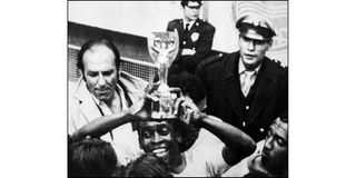 Brazilian forward Pelé smiles as he holds aloft the Jules Rimet Cup 
