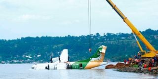 Workers use a crane to pull the crashed Precision Air aircraft out of Lake Victoria 