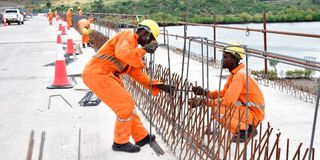 Construction workers fix rebars on the Mwache Bridge. 