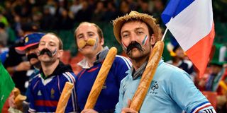 French rugby fans hold baguettes