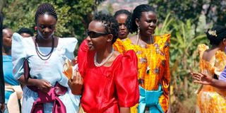 Ugandan women in colourful gomesi dresses.