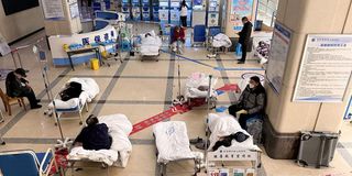 Covid-19 patients lie on hospital beds 