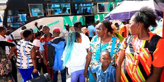 Passengers board a bus at a bus station in Mombasa
