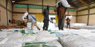 Workers offload fertiliser from a truck to a godown at the National Cereals and Produce Board, Eldoret depot