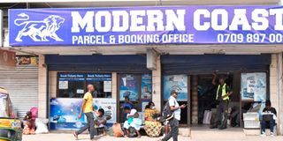 Passengers wait for buses outside a Modern Coast booking office in Mombasa