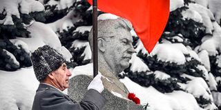 A Soviet army veteran stands next to the tomb of late Soviet leader Joseph Stalin
