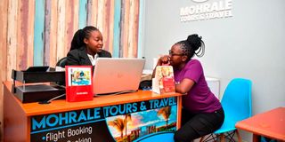 Vanish Moraa (middle) director of Mohrale Tours and Travel attending to a client at her office in Eldoret 