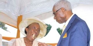 Retired Reverend Canon David Kinyanjui Macharia (right) gives his wife Rosemary Mugure Kinyanjui (left) a cake