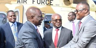 President William Ruto (left) is welcomed to Homa Bay by ICT Cabinet Secretary Eliud Owalo