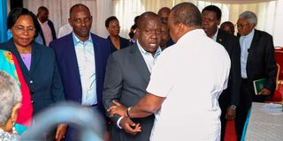 Former President Uhuru Kenyatta shares a word with former interior Cabinet Secretary Dr Fred Matiangi