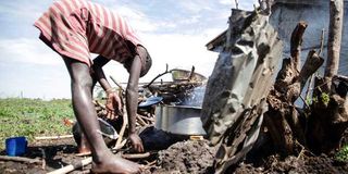 A child cooks outside her home in Kisumu